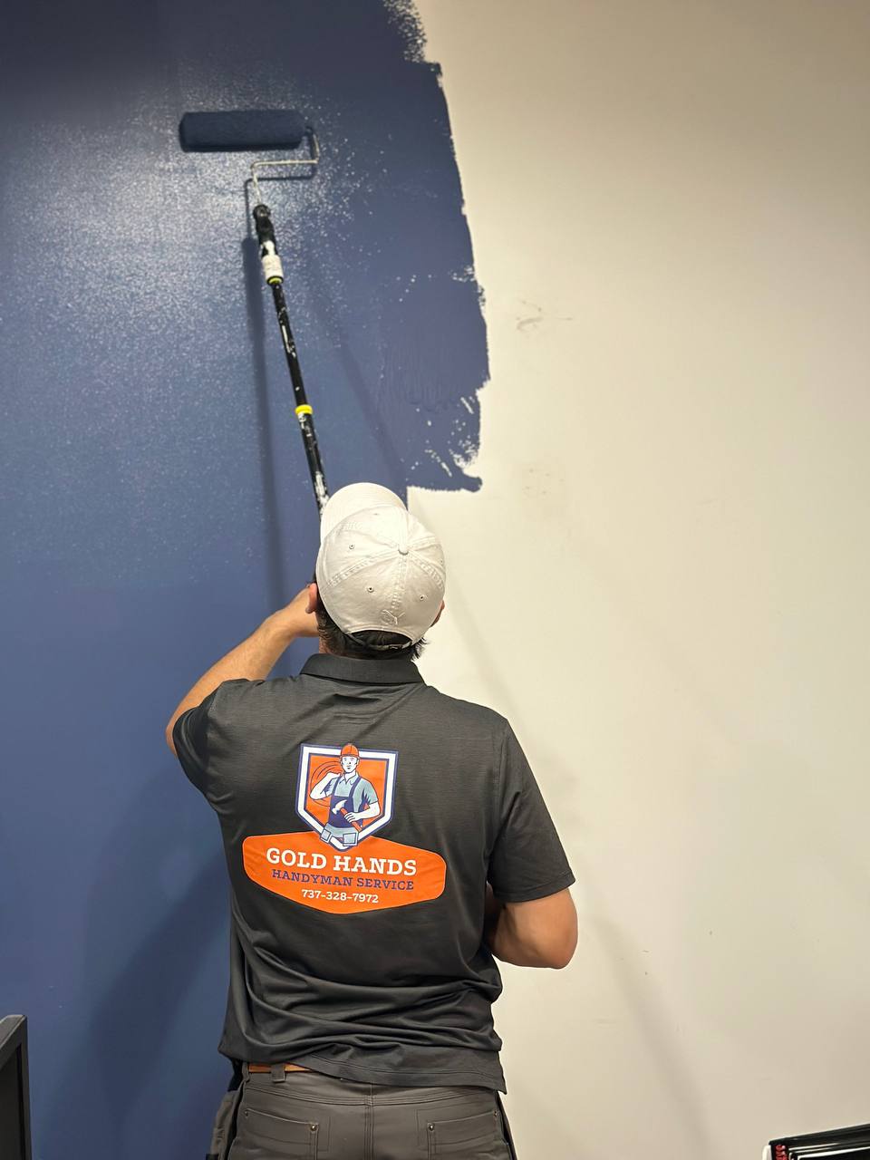 Gold Hands technician painting interior wall in Miami home