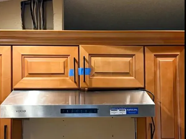 After: stainless range hood installed in the same space
