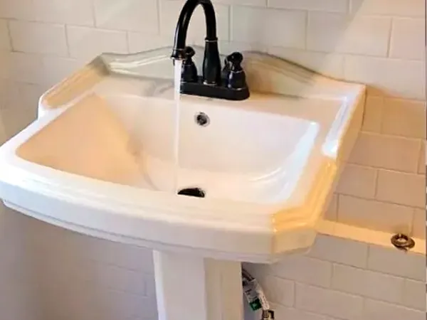 After: new pedestal sink and black faucet